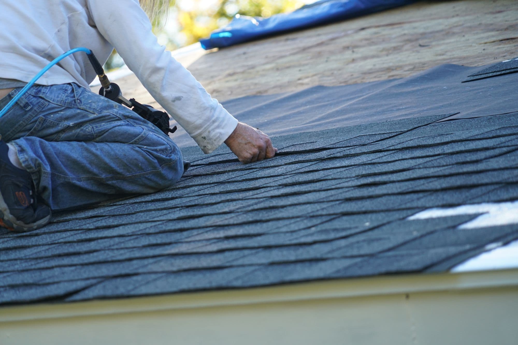 Roofer installing asphalt shingles