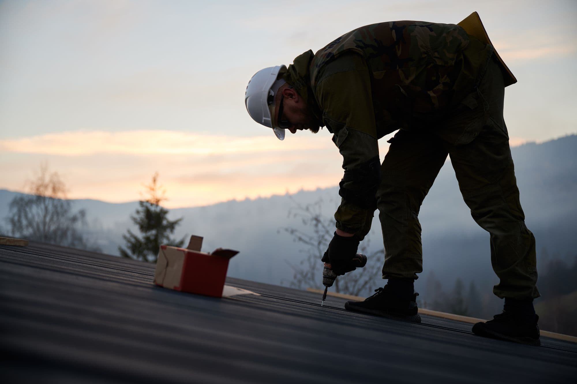 Roofer working at sunset